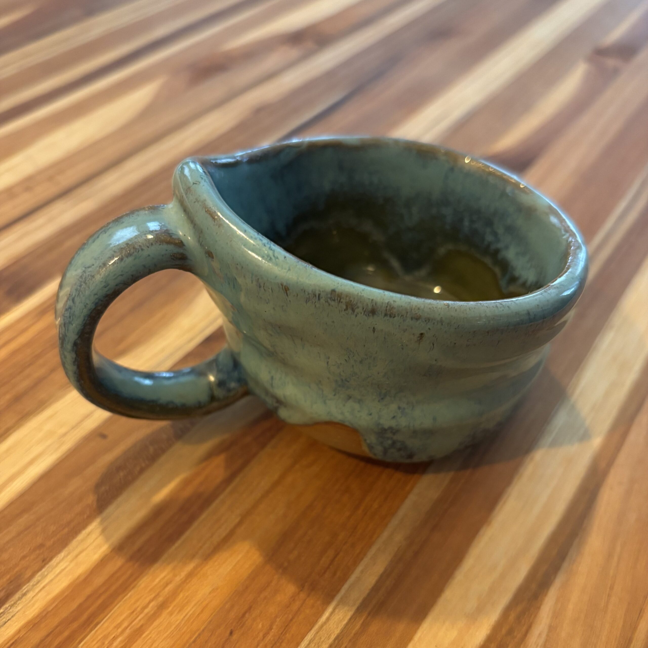 A lopsided uneven green mug.