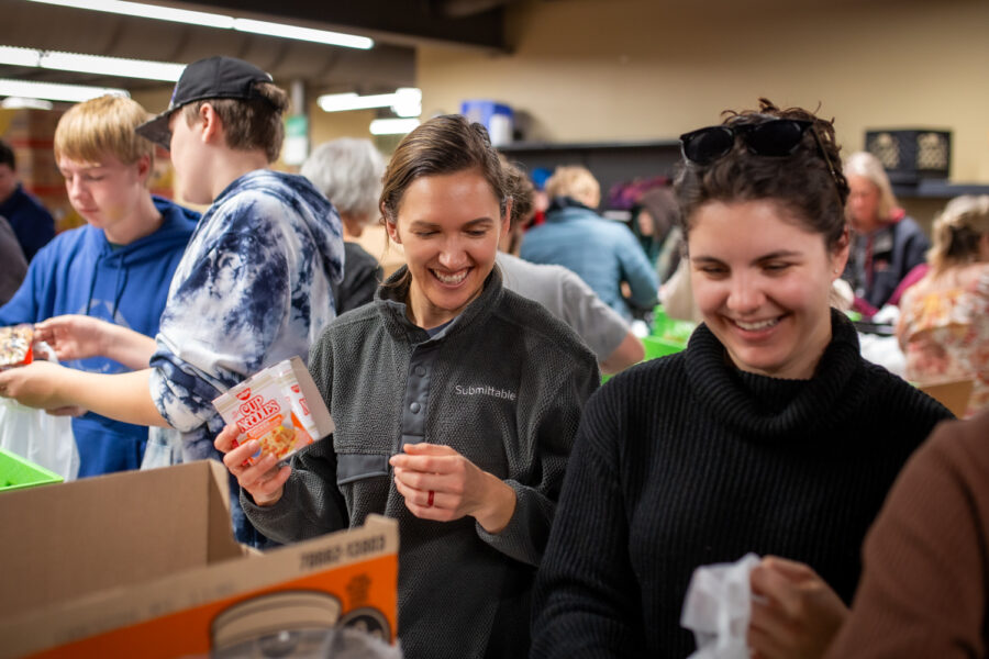 Submittable employees volunteering at a local food kitchen packing food for Thanksgiving kits.